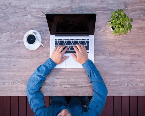 A clean desk with a notebook and a plant