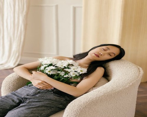 A person closing their eyes gently relaxing in a chair